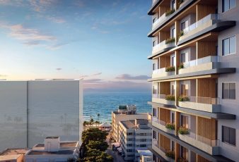 Vista para o mar a partir da fachada do House Macapá 211 em Ondina, Salvador, com varandas e edifícios ao redor