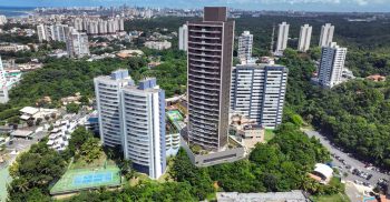 Vista aérea da implantação do TOM Colina de Patamares na Colina de Patamares, mostrando o empreendimento, a orla de Salvador, áreas verdes e o entorno do bairro.