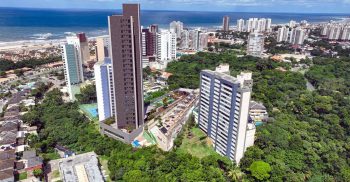 Vista aérea da implantação do TOM Colina de Patamares na Colina de Patamares, mostrando o empreendimento, a orla de Salvador, áreas verdes e o entorno do bairro.